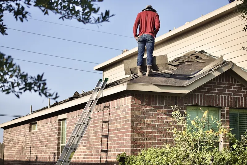 Professional roofer working on a residential roof in Hiland